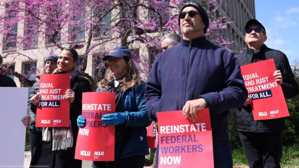 Rally where people are holding signs that say "Reinstate Federal Workers Now"