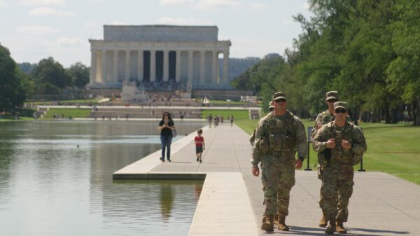 National Guard members in fatigues walking in front of the Lincoln Memorial.