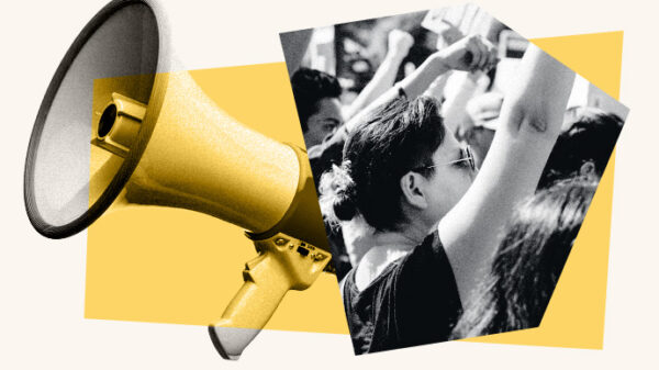 yellow megaphone is positioned on the left side of the image, overlapping a black-and-white photo of a crowd with raised fists, symbolizing protest or activism. The background features abstract yellow geometric shapes.