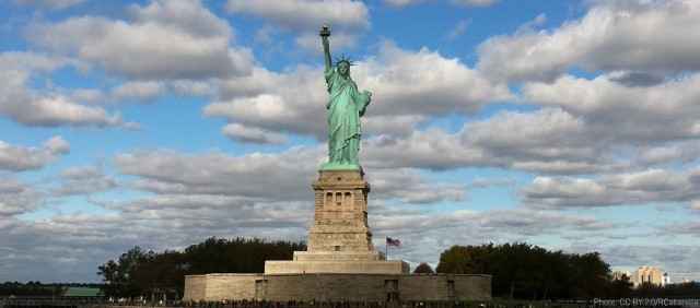 Wide shot of the Statue of Libery against a cloudy sky