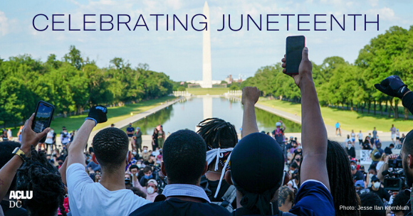 photo of protestors facing Washington Monument with fists raised