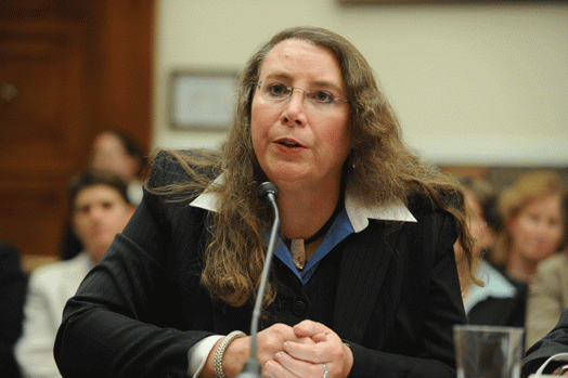 Schroer testifying before Congress in a dark colored jacket and a collared blouse